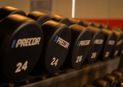 Close-up of Precor dumbbells neatly arranged in a gym for fitness enthusiasts.
