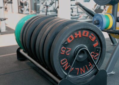 Close-up of stacked weight plates in a modern gym setting.