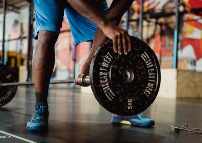 An athletic man preparing for a weightlifting session inside a vibrant gym.
